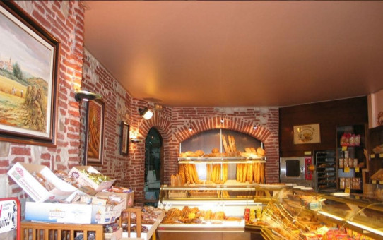 Bäckerei mit einer Wand mit sichtbaren roten Ziegelsteinen und einer matten braunen Decke