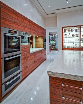 Moderne Küche mit edler Holzvertäfelung und massiver Arbeitsfläche