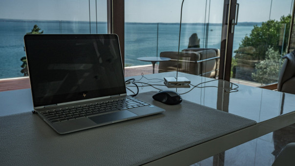 Schreibtisch mit Glasplatte und brauner Echtleder Lederauflage abgerundet durch ein edles Notbook von HP