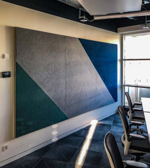 Warehouse 500 - Büroeinrichtung - München 5 Akustikpaneel in einer Büroumgebung mit geometrischem Design in Grautönen und Blau, sorgt für Schallabsorption.