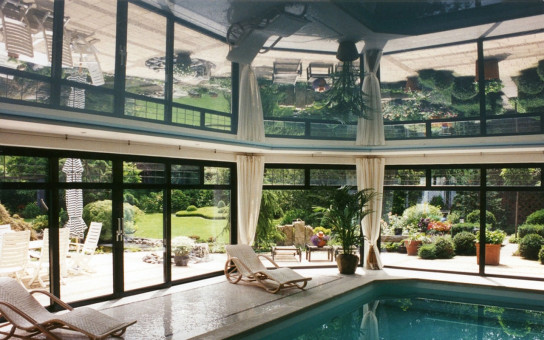 Hallenbad mit schöner Aussicht in den Garten mit einer raumumspannenden Spanndecke