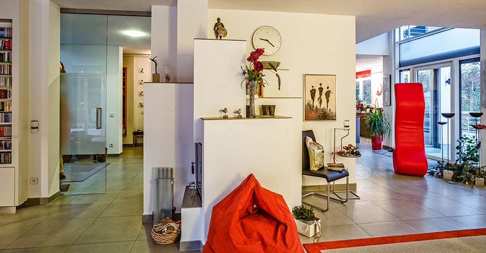 Wohnzimmer mit roten Möbeln und einer Schiebetüre aus Glas