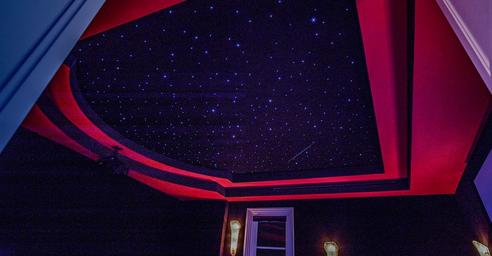 Schwarze Decke mit Sternen in einem Heimkino und roten Teppichelementen