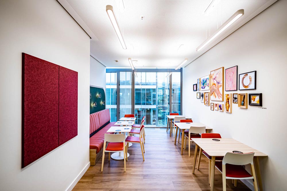 New Work - Essbereich einer Küche mit Akustikpaneelen und gerahmten Bilder in München