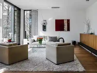 Schreinerei München - Arve Einrichtung GmbH 24 Helles Wohnzimmereinrichtung mit grauer Sofalandschaft, Glastisch und Sideboard aus Eichenholz