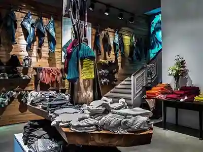 Schreinerei München - Arve Einrichtung GmbH 23 Inneneinrichtung eines Modeladens mit massivem Holztisch mit 15cm dicker Eicheplatte und Holzvertäfelung in Eiche rustikal von unserer Schreinerei in München